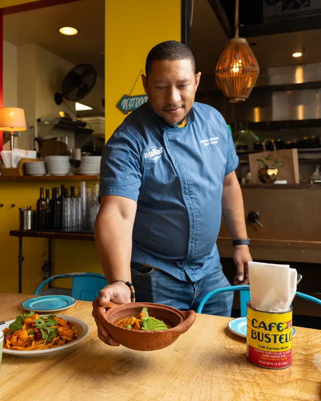 Chef Nelson German serving a clay bowl at alaMar, Oakland