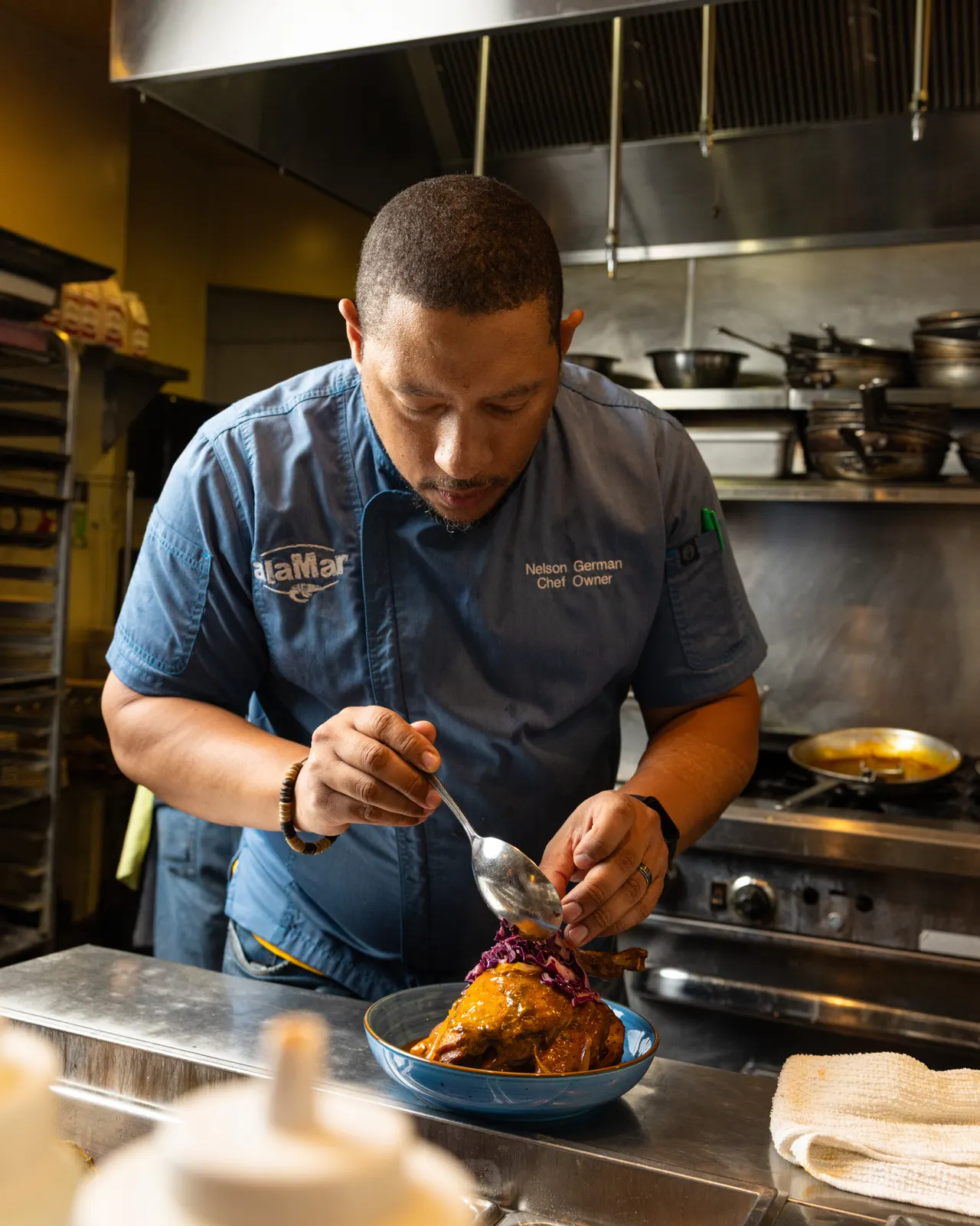 The chef plating at the pass at alaMar, Oakland