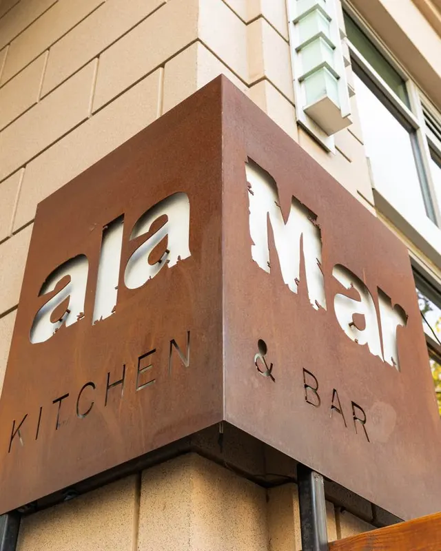 The corten-steel corner sign outside alaMar Kitchen & Bar, Oakland