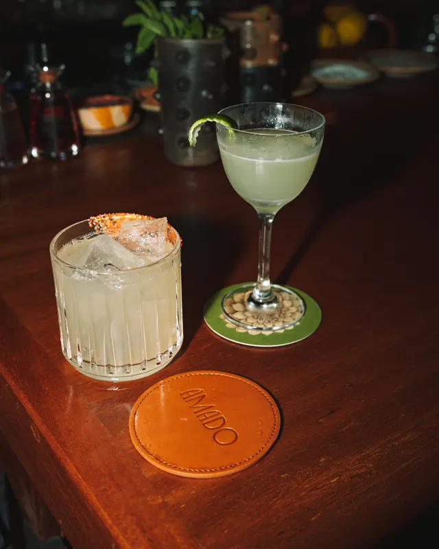 A mezcal margarita pair on leather coasters at Amado, Burlingame