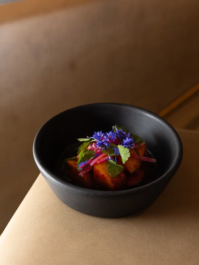 A black bowl finished with cornflowers at Arquet, San Francisco