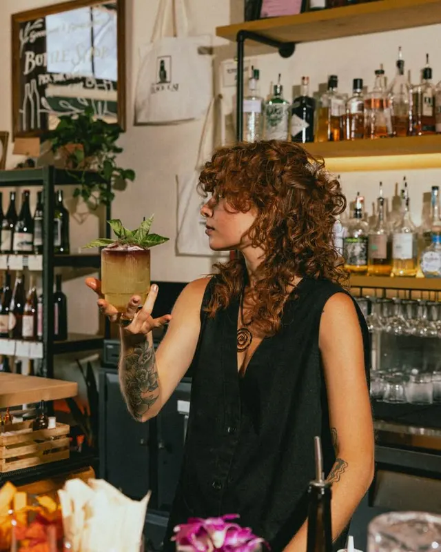 The bartender balancing a garnished cocktail on one palm at The Black Cat, Livermore