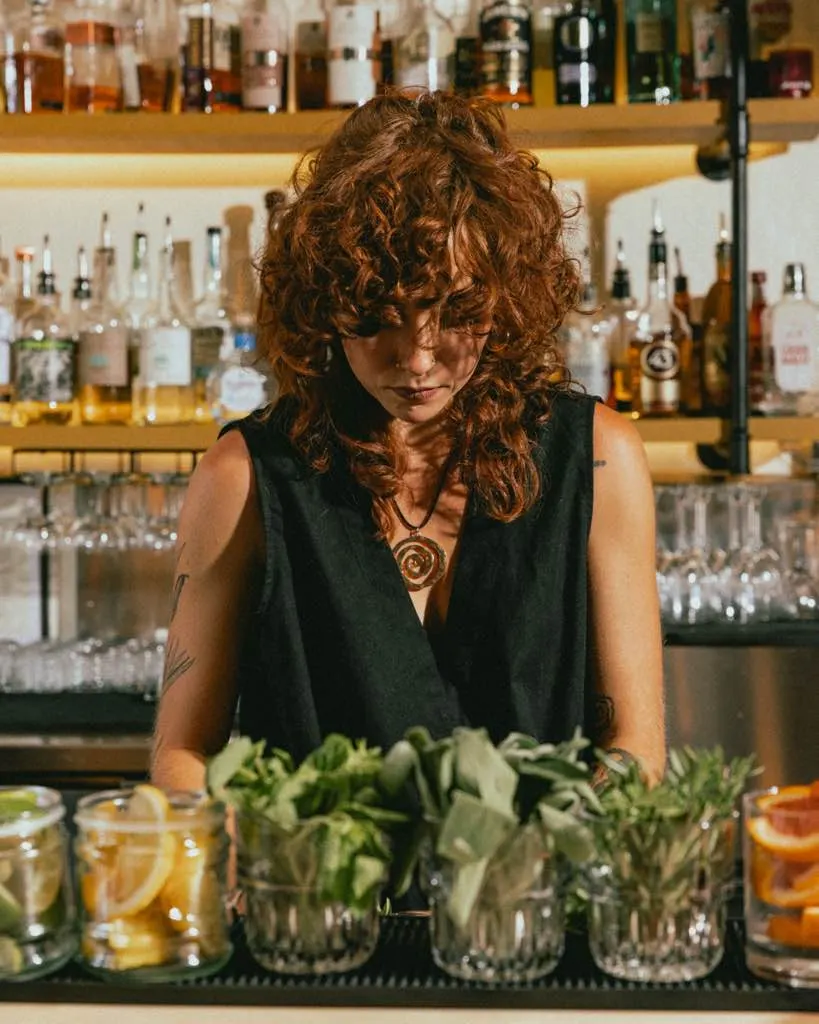 Bartender working over jars of fresh herbs and citrus at The Black Cat, Livermore