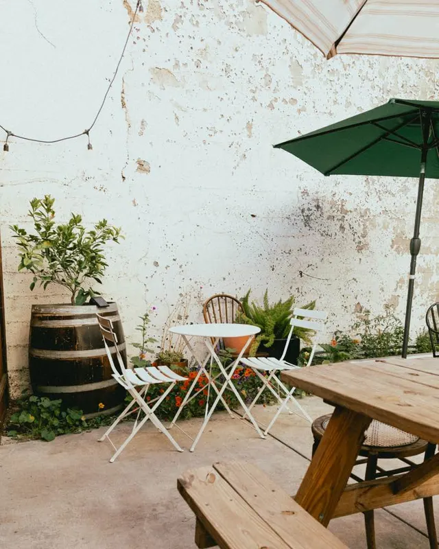 Cafe tables and a green umbrella on the patio at The Black Cat, Livermore
