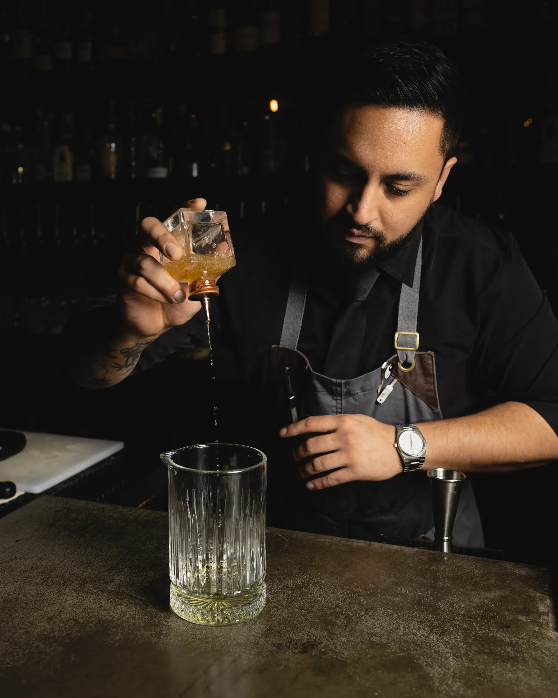 A bartender pouring a spirit down into the glass at Distrito Federal, Campbell