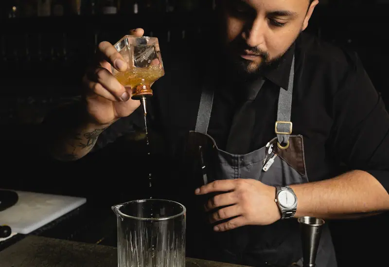 A bartender pouring a spirit down into the glass at Distrito Federal, Campbell, the cocktail photography portfolio