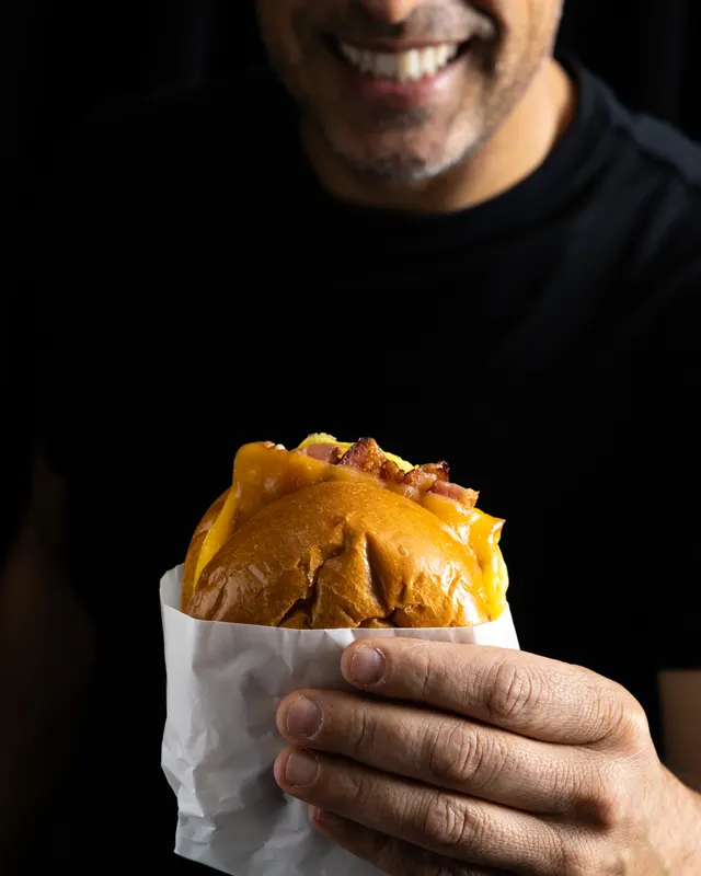 A wrapped brioche burger held to the light for Handheld Catering, Santa Clara