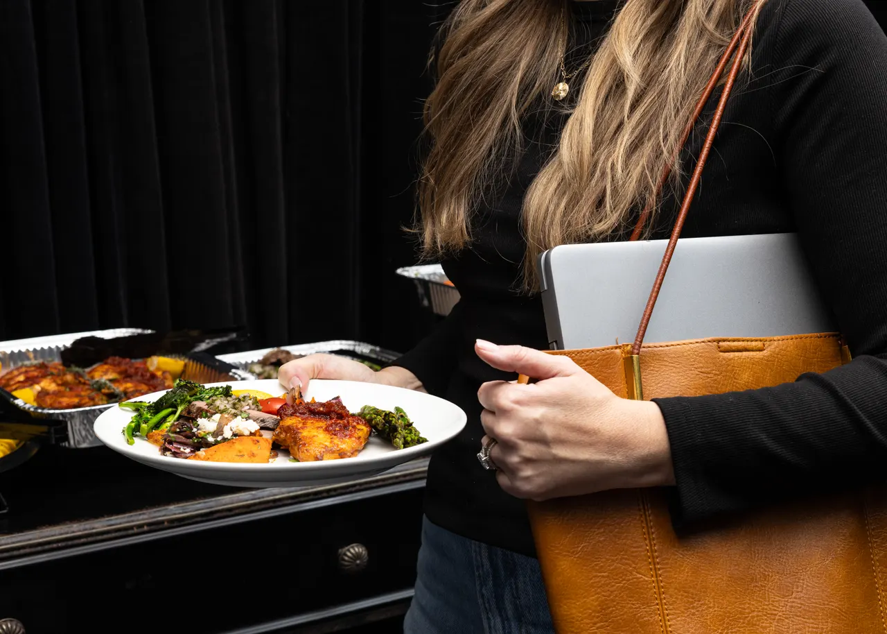 A guest plate in hand, laptop bag on the shoulder, for Handheld Catering, Santa Clara