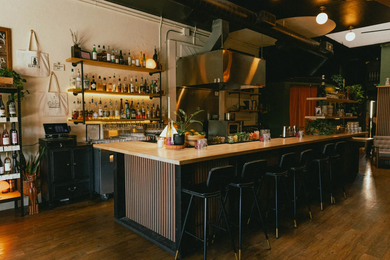 The bar at The Black Cat, Livermore, warm shelves under a dark ceiling
