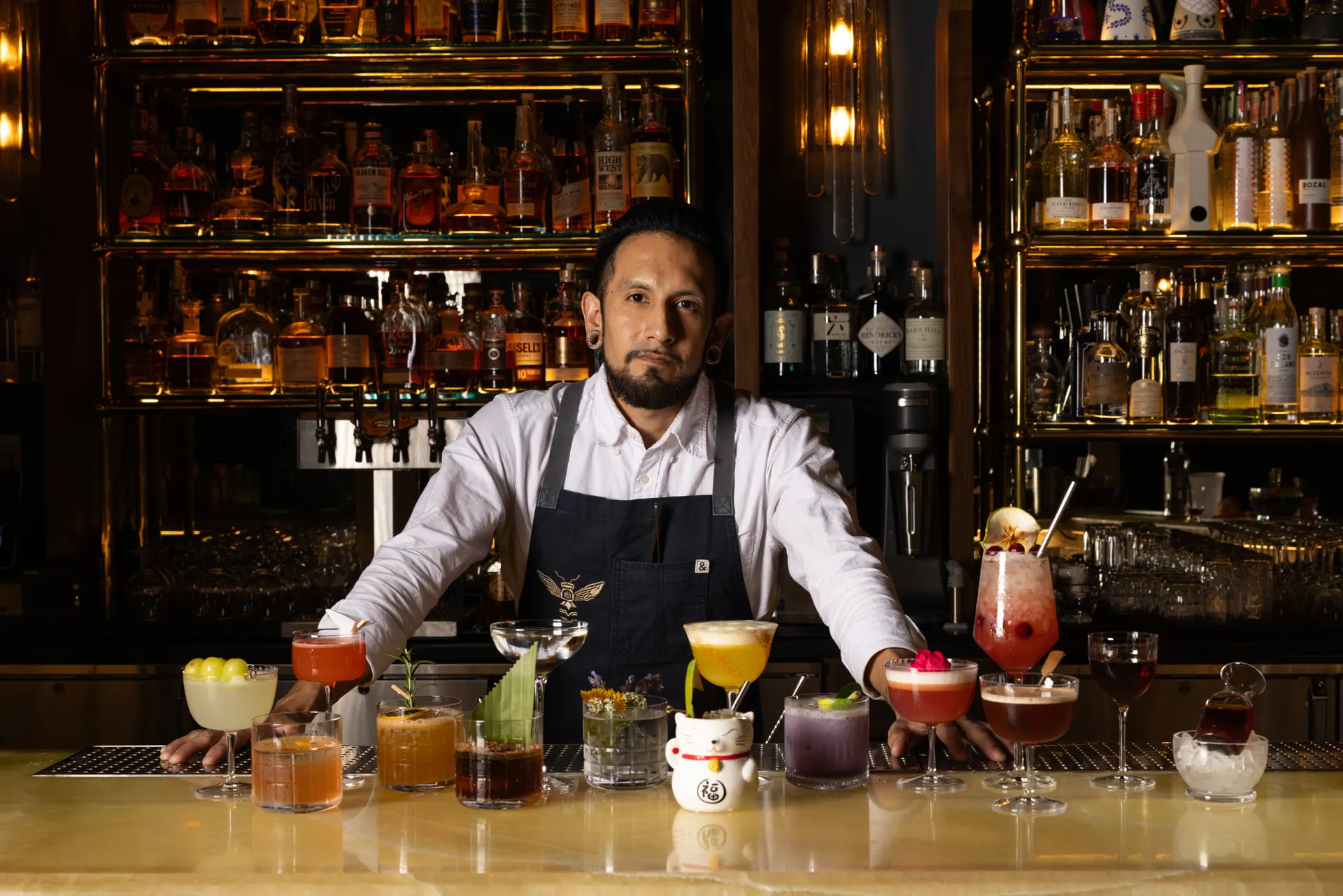 The bartender behind a lineup of house cocktails at Honeycomb Cocktail Lounge, Livermore
