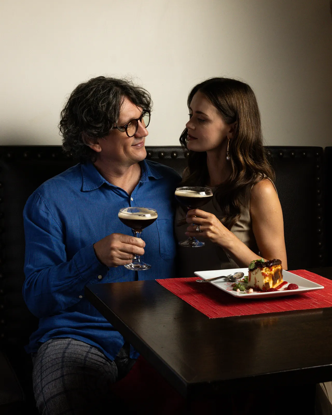 A couple toasting espresso martinis in a booth at the Hotel Valencia bar, Santana Row, San Jose