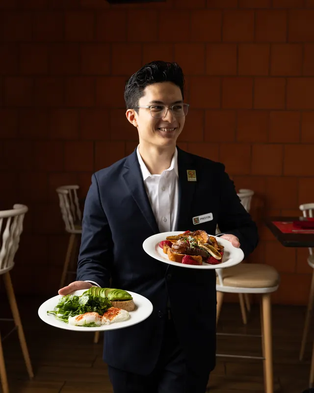A server mid-stride with two plates at Hotel Valencia, San Jose