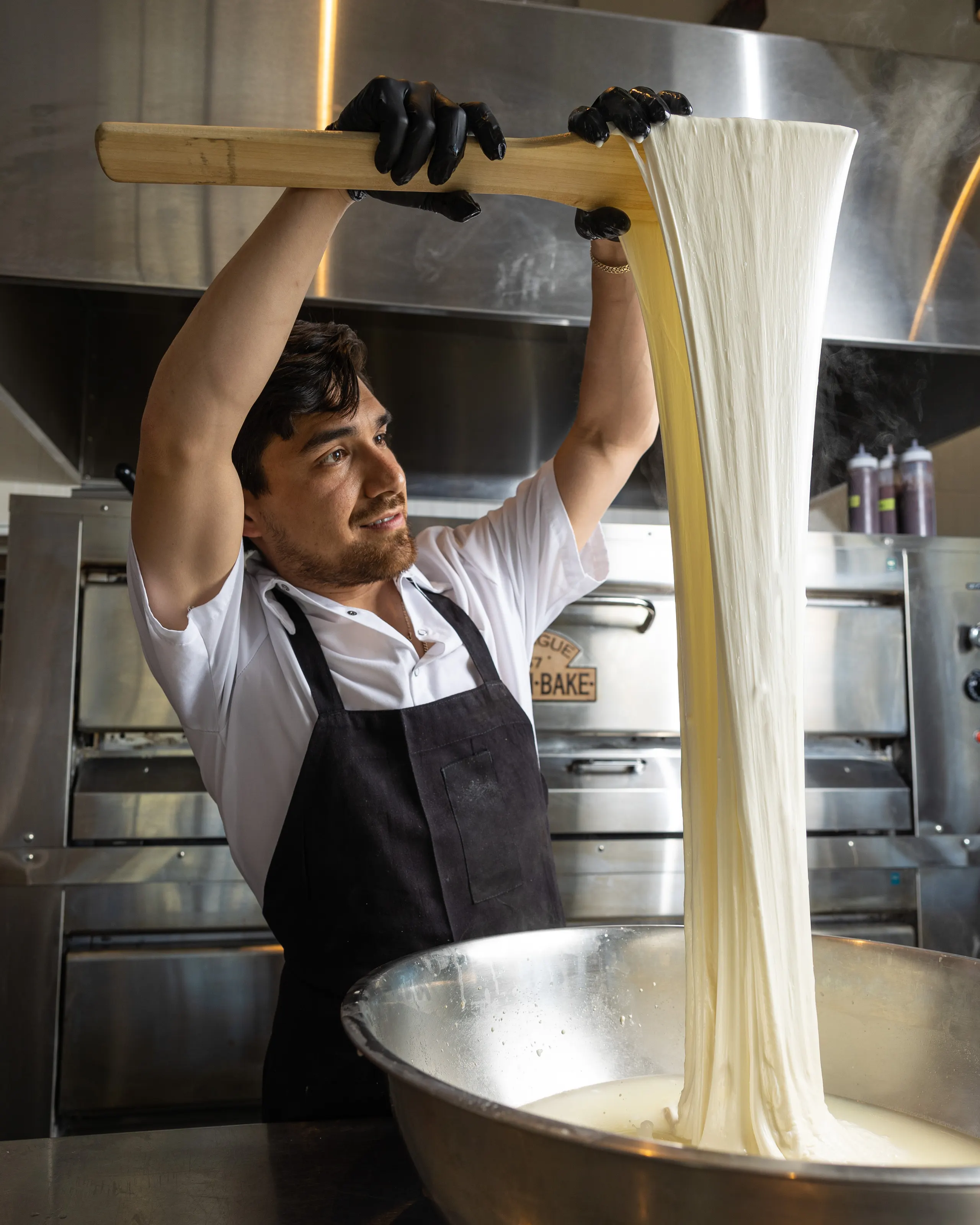 A chef stretching fresh pasta dough overhead at Il Parco, San Francisco