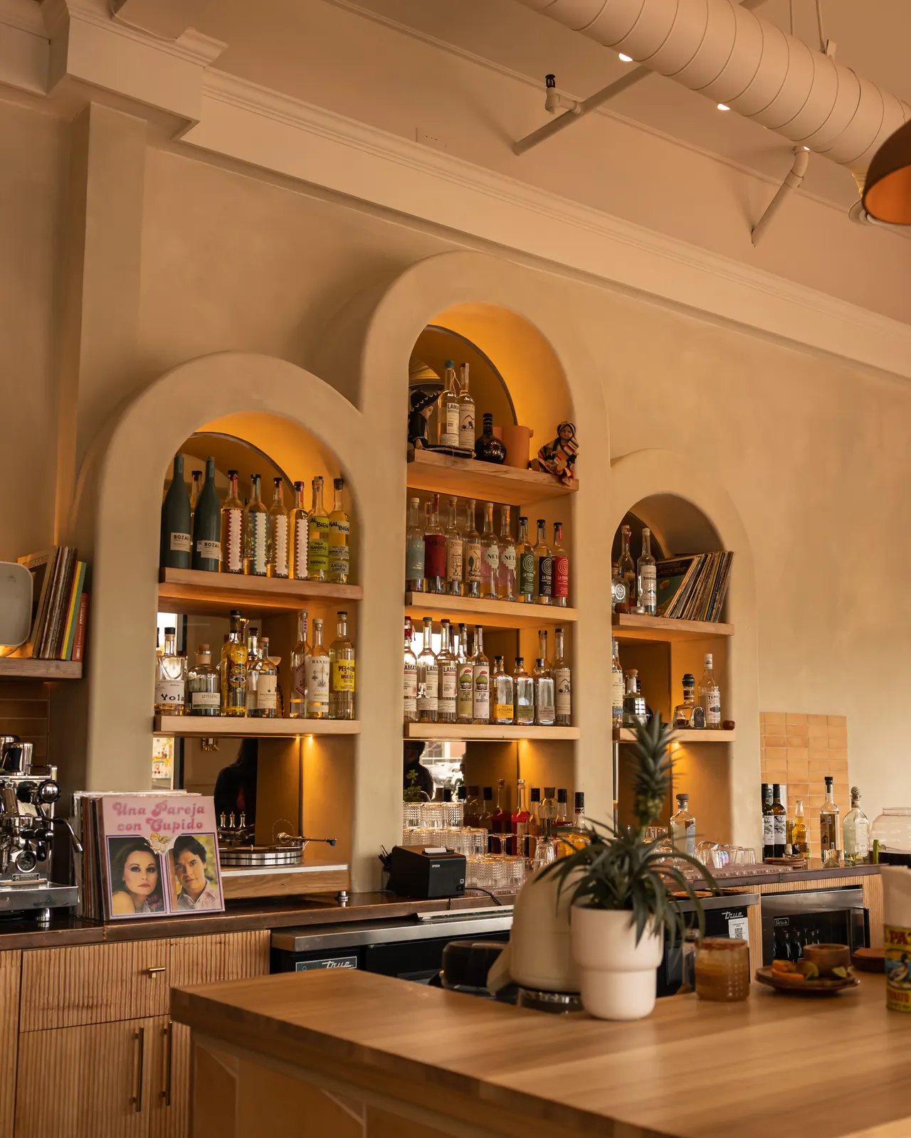 The arched back bar glowing at Mía Mezcaleria, Oakland