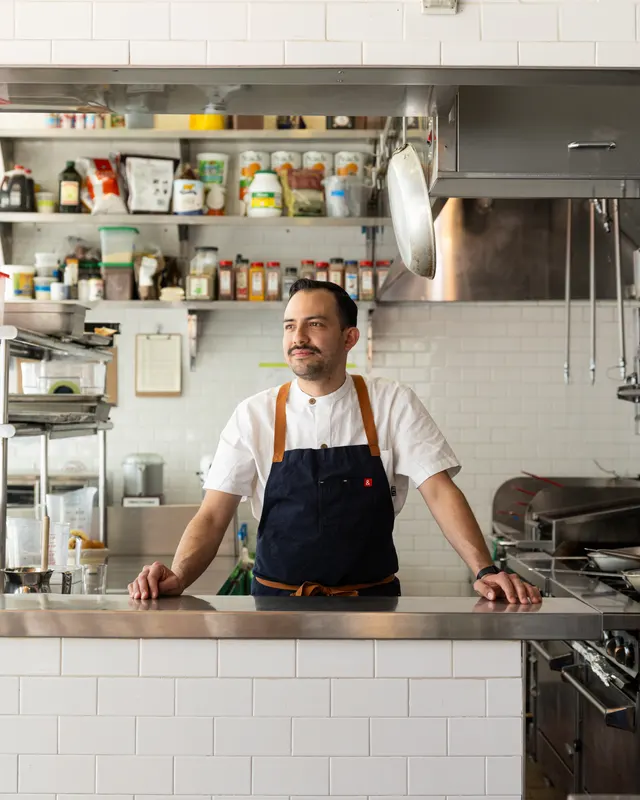Chef portrait at the pass in a white-tiled kitchen at Pacífico, San Francisco