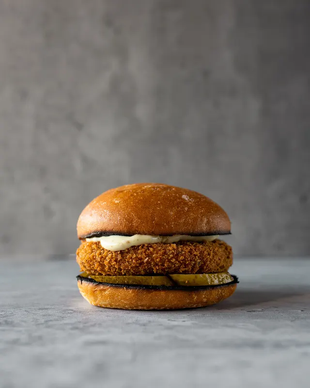 The finished burger on seamless grey, the hero frame of a recipe series - recipe photography by Lemonad Media