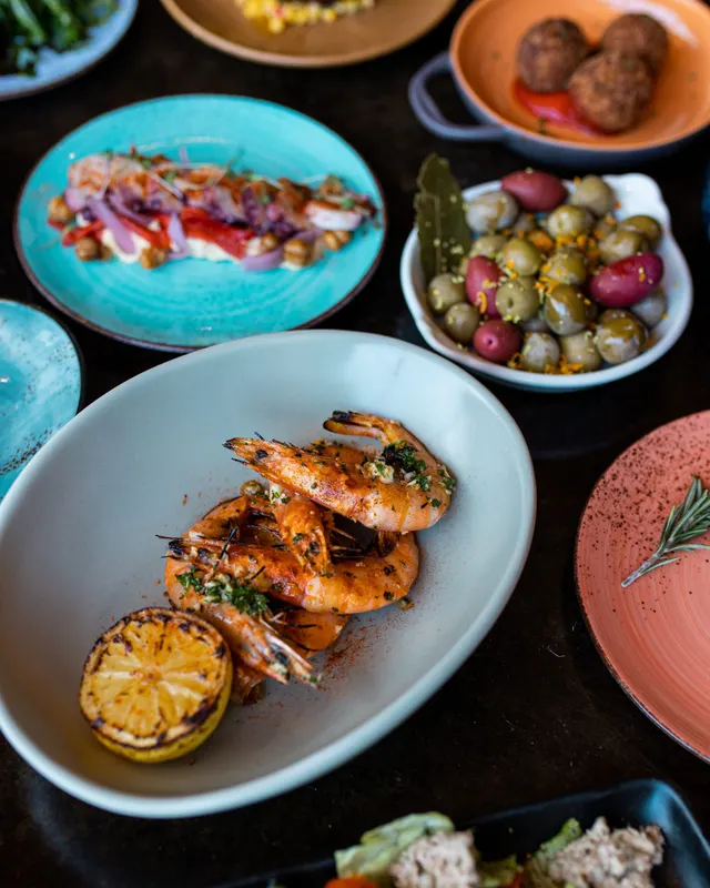 Grilled prawns and marinated olives plated to match the series - recipe photography by Lemonad Media