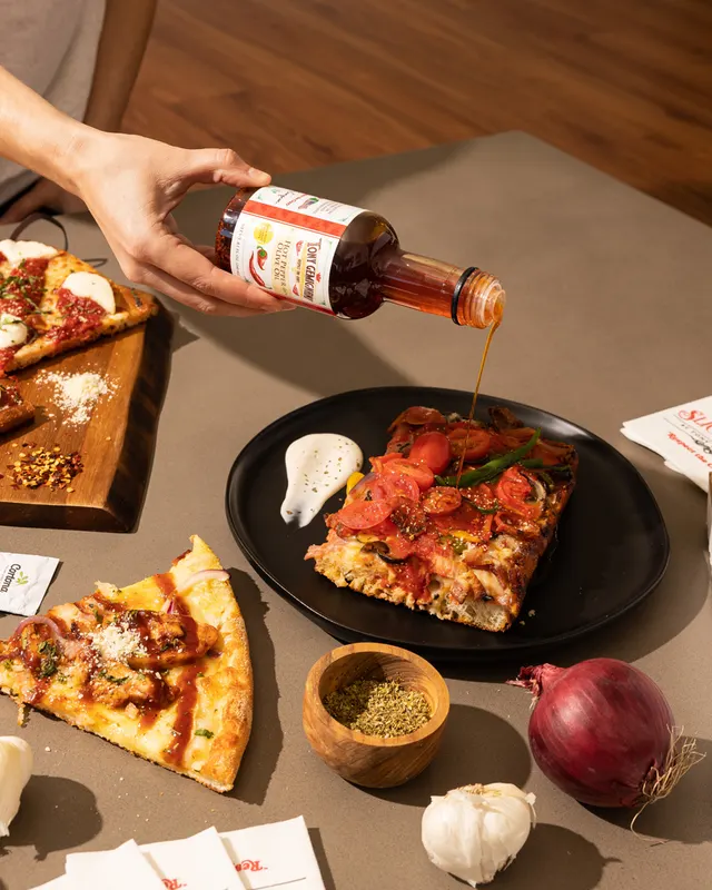 Hot honey poured over a pepperoni slice for Slice House by Tony Gemignani