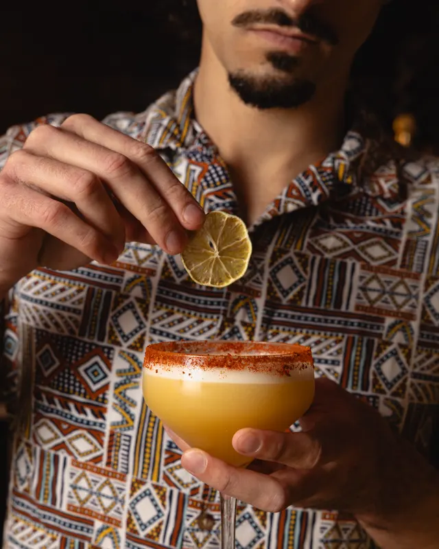 A tajín-rimmed coupe garnished by hand at Sobre Mesa, Oakland