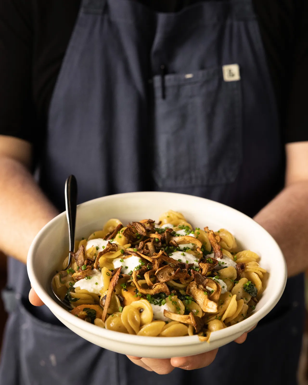 The chef holding a finished rigatoni bowl at Sons of Liberty Alehouse, San Leandro
