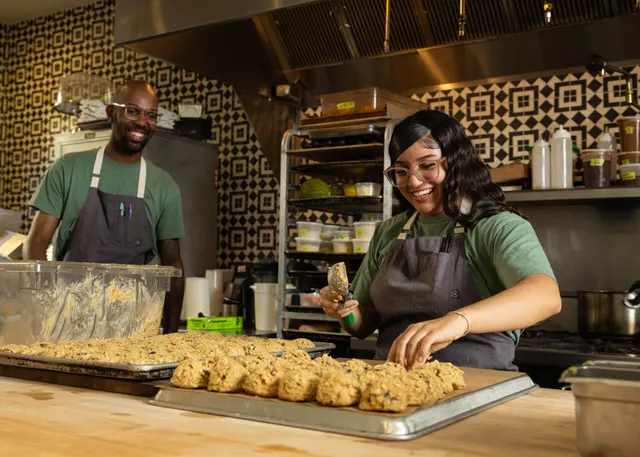 Bakers scooping cookie dough in a commercial kitchen at Sprouts Chef Training, Oakland