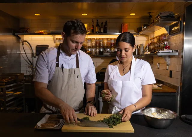 Two cooks prepping shoulder to shoulder at Sprouts Chef Training, Oakland