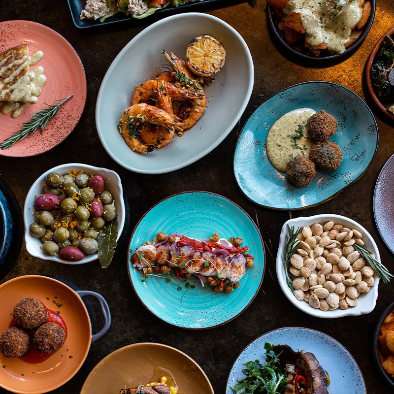 Tapas spread from above on a dark wood table at La Marcha, Berkeley