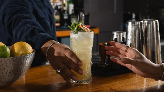 A garnished collins handed across the bar at Town Tavern, Alameda