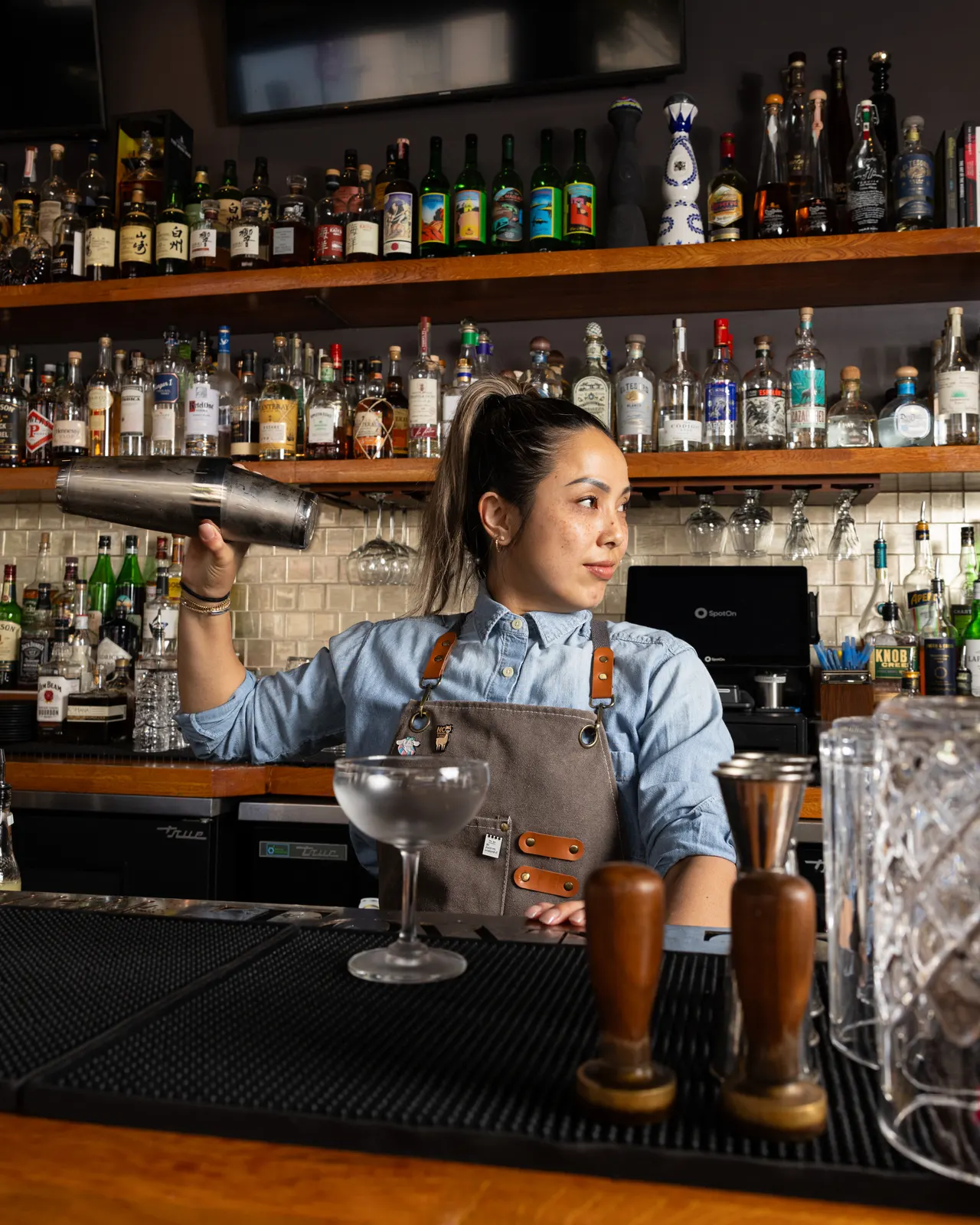 Bartender working a shaker tin behind the bar at Town Tavern, Alameda