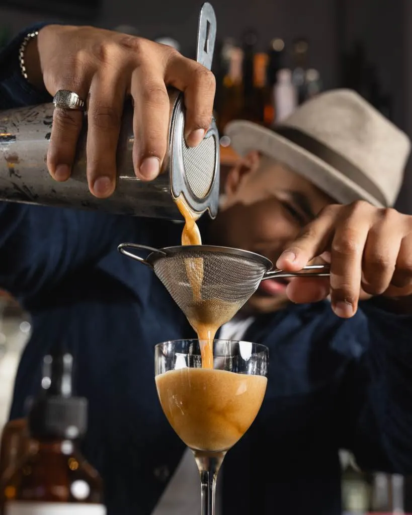 A double-strained pour under the brim of a hat at Town Tavern, Alameda