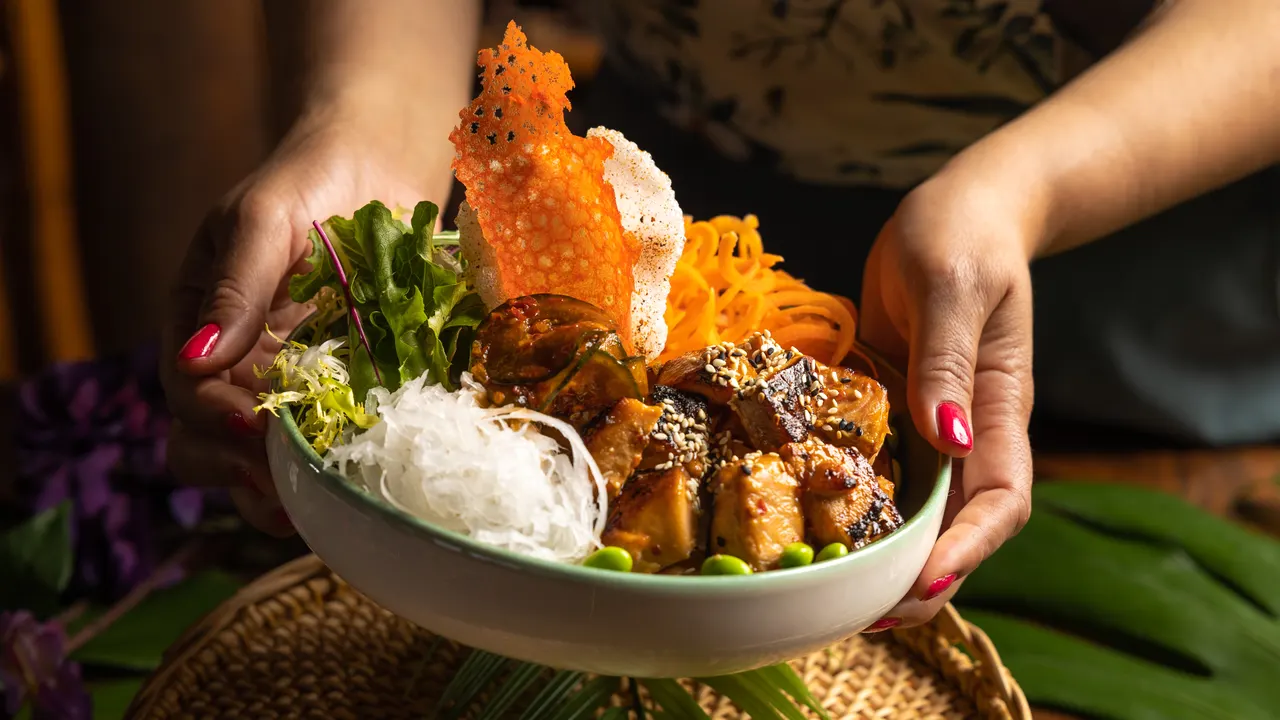 A crab-topped bowl presented over the woven mat at Trader Vic's, Emeryville